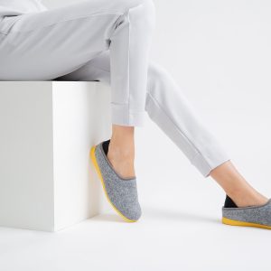person in gray pants wearing blue and yellow flats