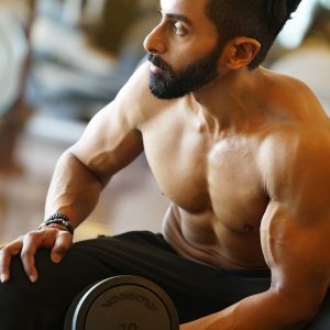 topless man holding dumbbell